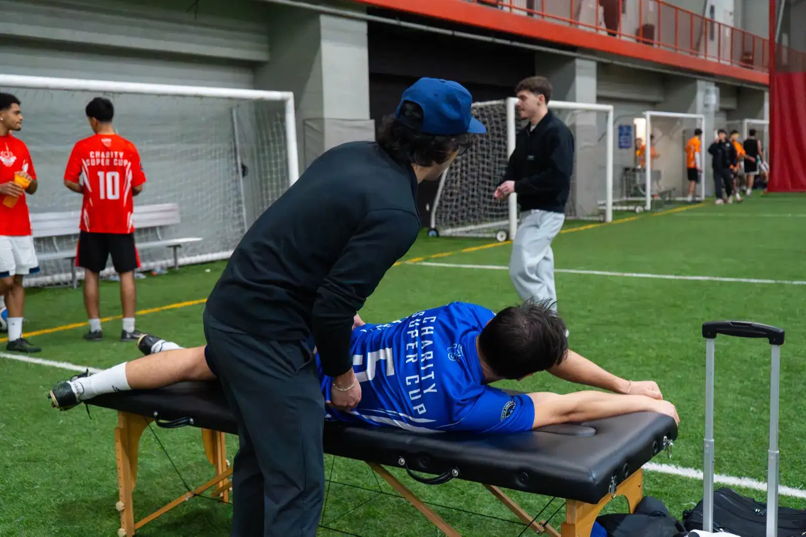 Physio student stretching a player's back on a treatment table