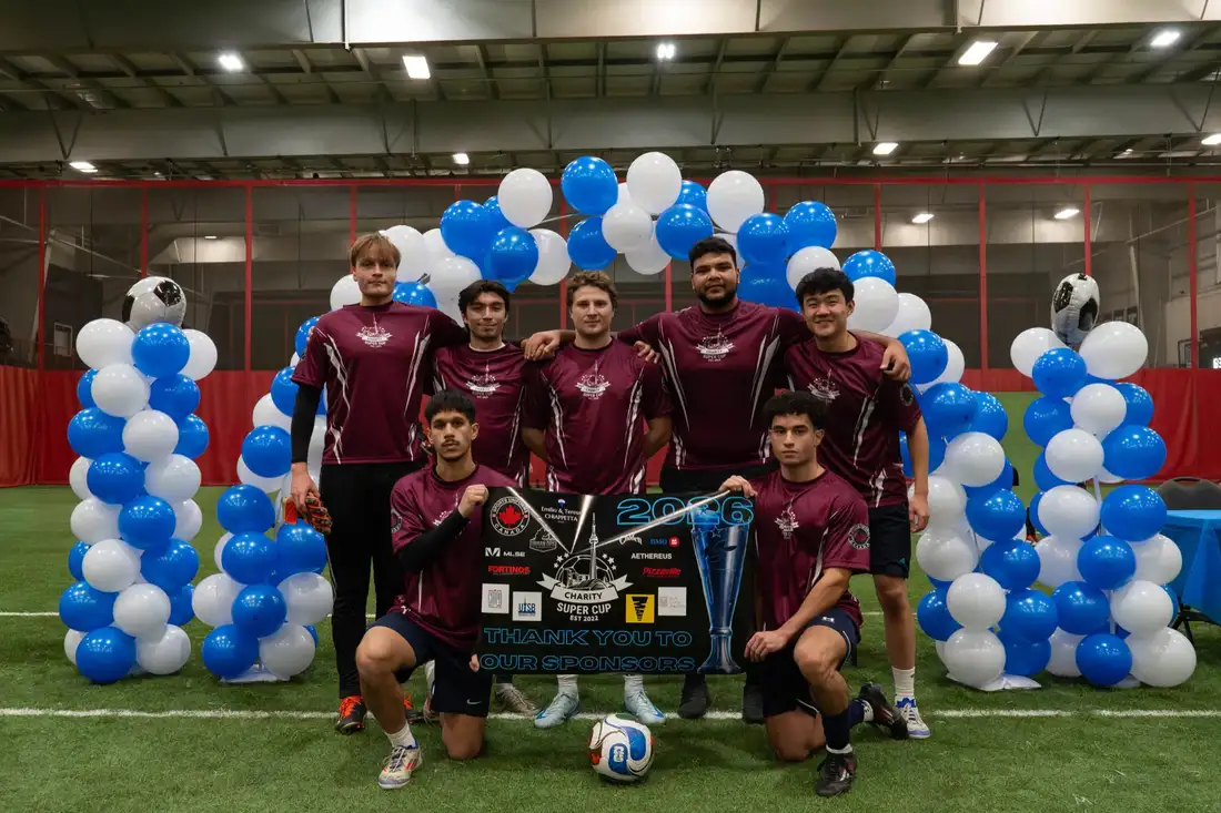 Team holding the Charity Super Cup sponsor thank-you banner