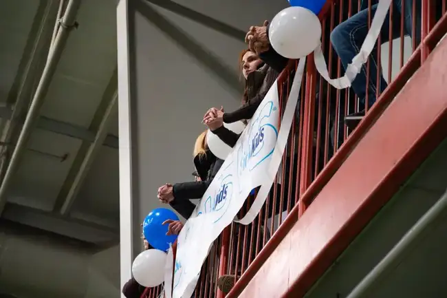 Fans cheering with a SickKids banner in the stands
