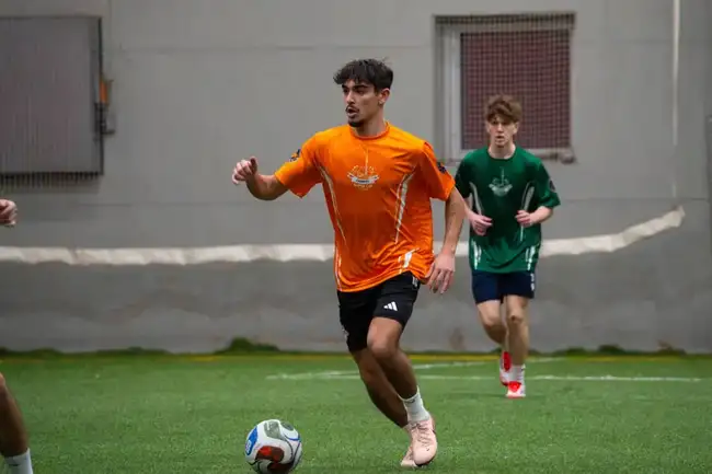 Players in orange and green jerseys in action