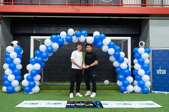 Organizers holding the tournament trophy together