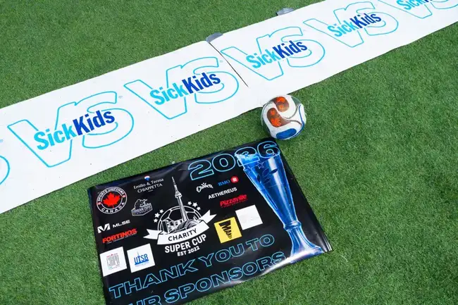 Sponsor banner and match ball on the turf